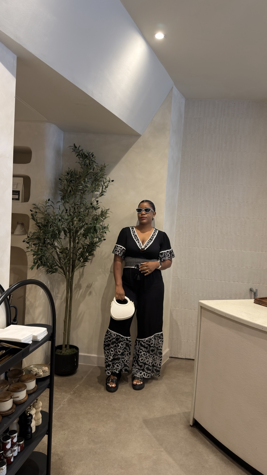Owner OC wearing a black and white outfit in a warm, contemporary interior